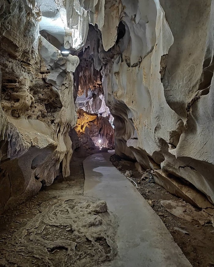 Hình ảnh của một hang động với những khối nhũ đá và stalactites treo lơ lửng, tạo nên một không gian huyền ảo.